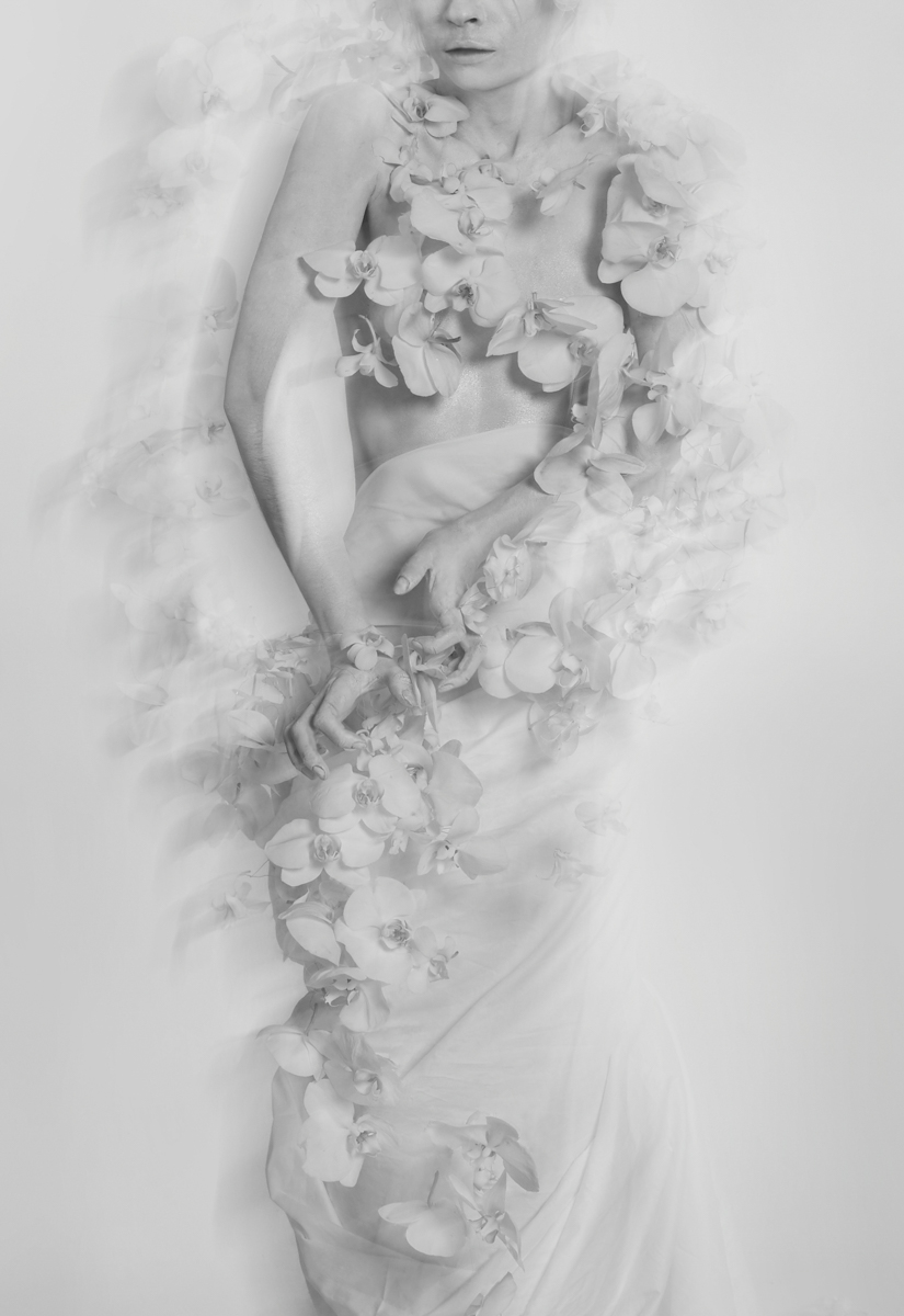 Flower installation with white floating orchids around a girl painted in white body black and white photo by Florist and set designer in Shanghai China Daria Bokova