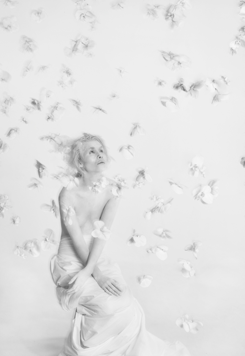 Flower installation with white floating orchids around a girl painted in white body black and white photo by Florist and set designer in Shanghai China Daria Bokova