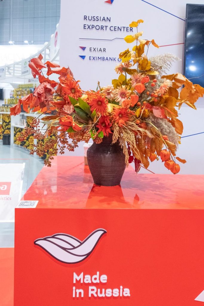 Fall flower arrangement Large reception centerpiece in a clay pot with red and orange fall flowers, leaves and berries by Shanghai florist Daria Bokova