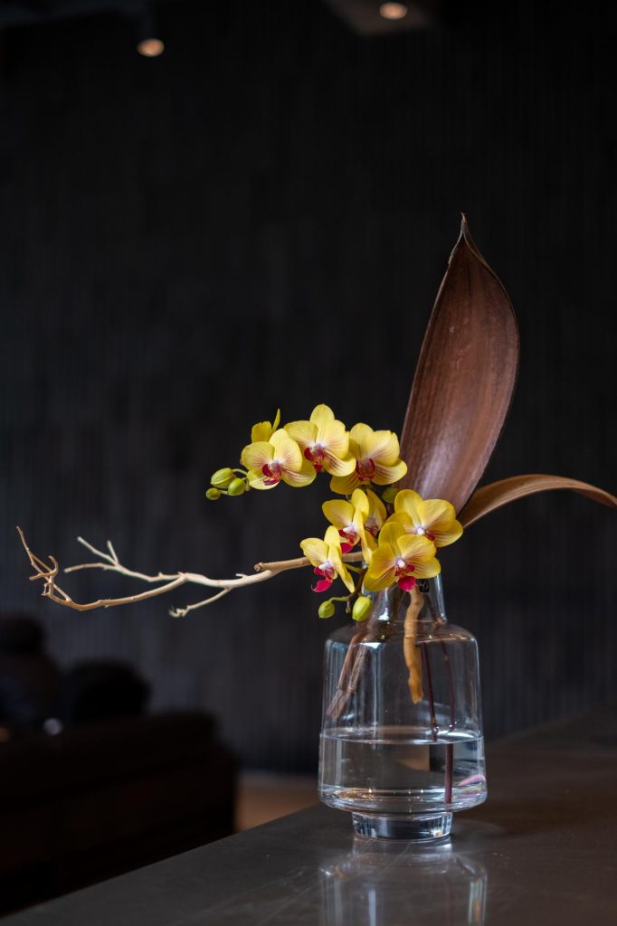 flower arrangement in vase with dried cacao leaves and Phalaenopsis orchid by Florist and set designer in Shanghai China Daria Bokova